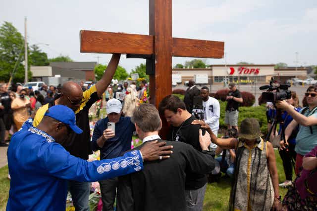 <p>Community members pray at a memorial site for the victims of the Buffalo mass shooting  </p>