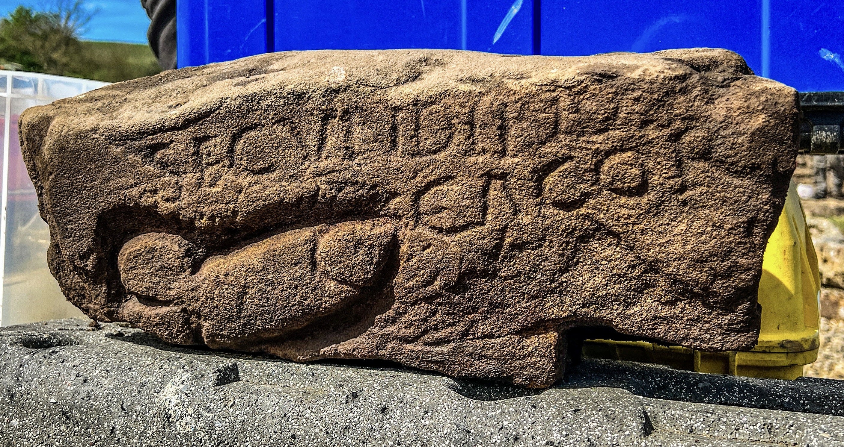 The stone shows a large phallus next to the name of a Roman soldier and the word “Cacor”