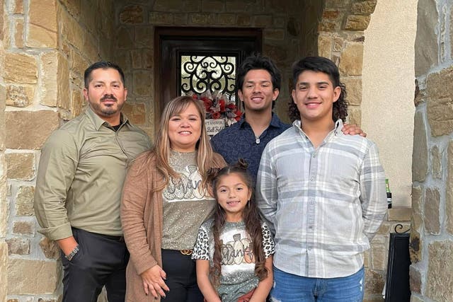 <p>A picture of Jacob Alabarado, a CBP officer, and his family</p>