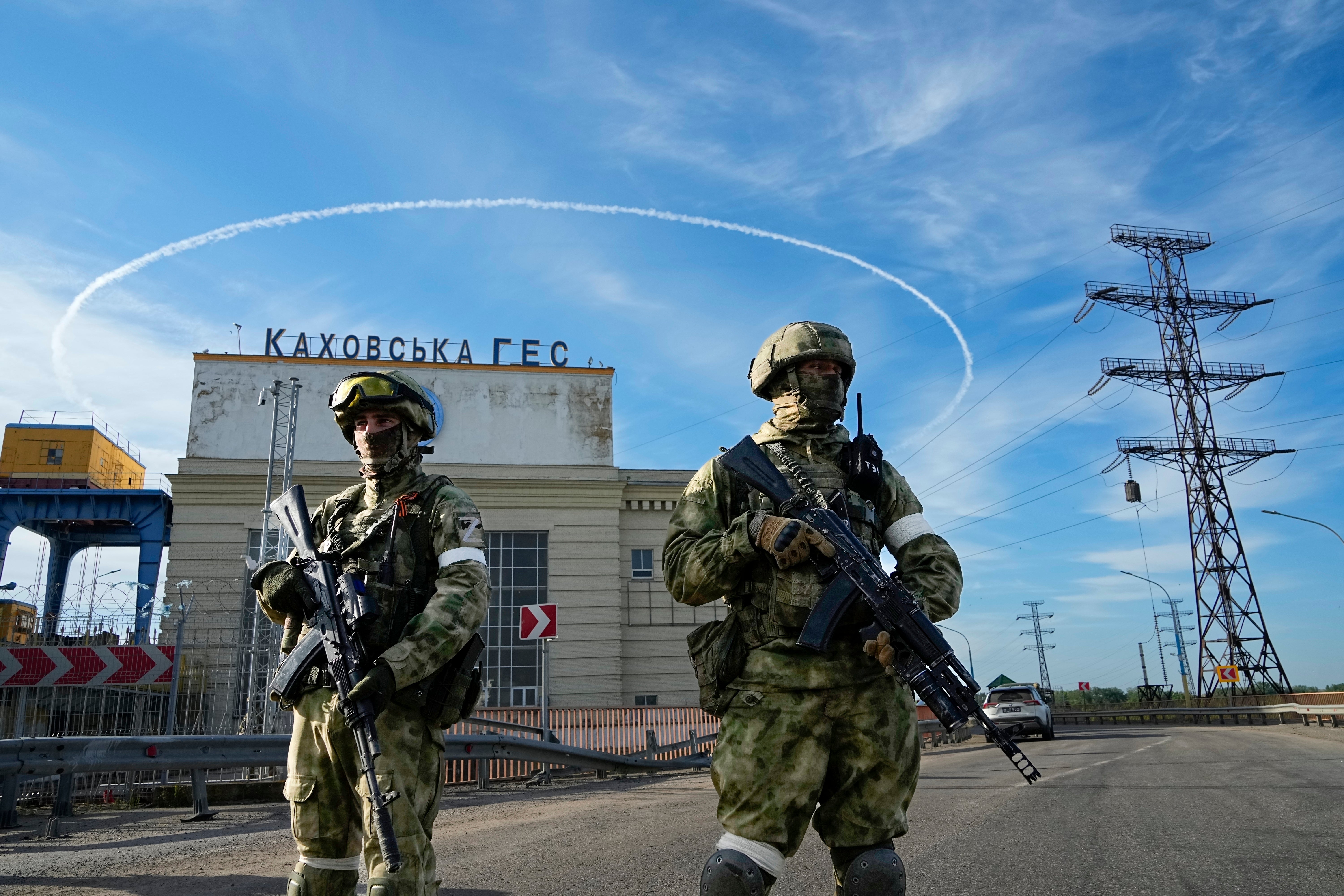 Russian troops guard an entrance of the Kakhovka Hydroelectric Station, in Kherson region of southern Ukraine