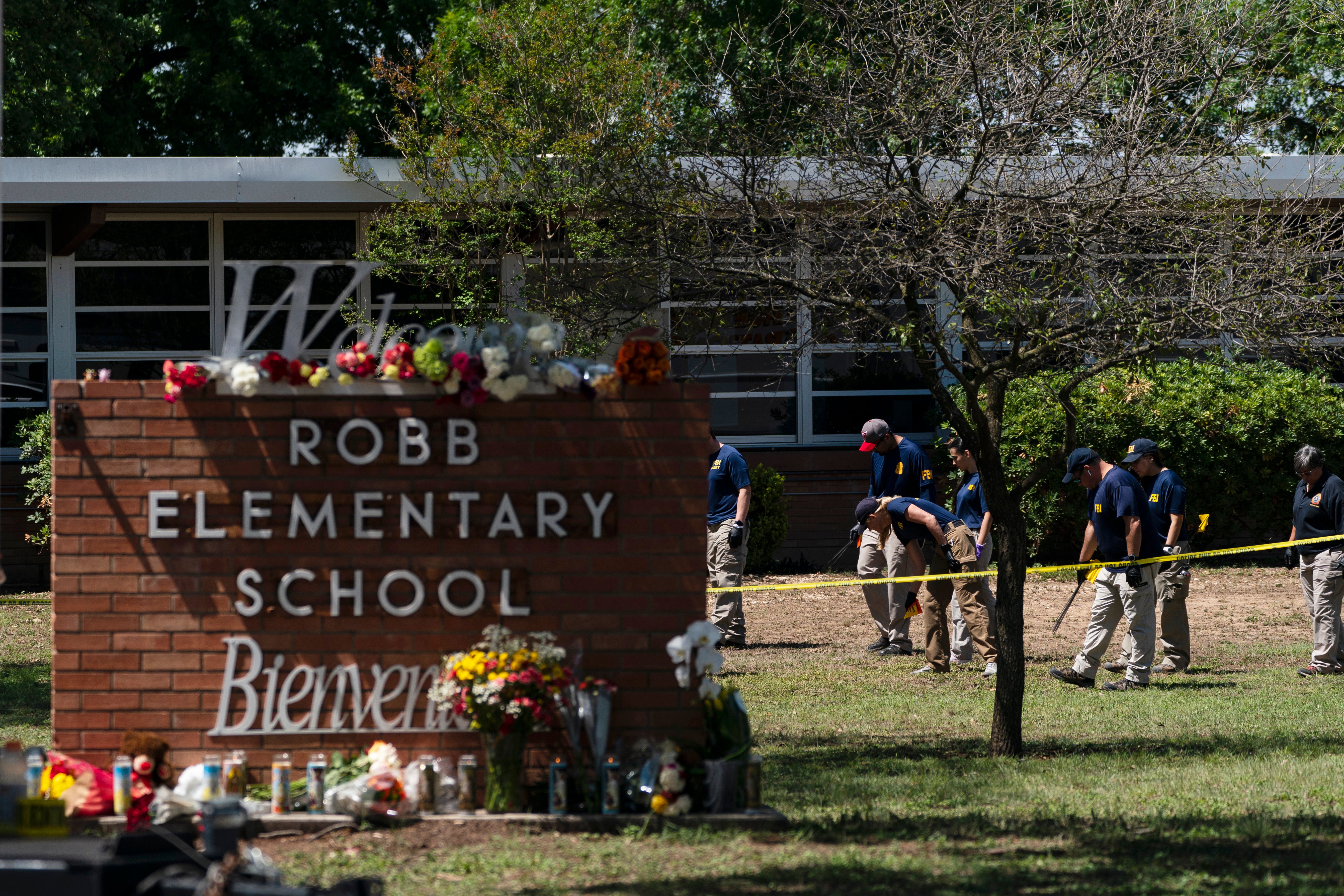 FILE - Investigators search for evidence outside Robb Elementary School in Uvalde, Texas, May 25, 2022.