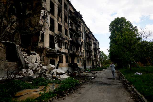A man walks in front of a damage building ruined by attacks in Hostomel on the outskirts of Kyiv (Natacha Pisarenko/AP/PA)