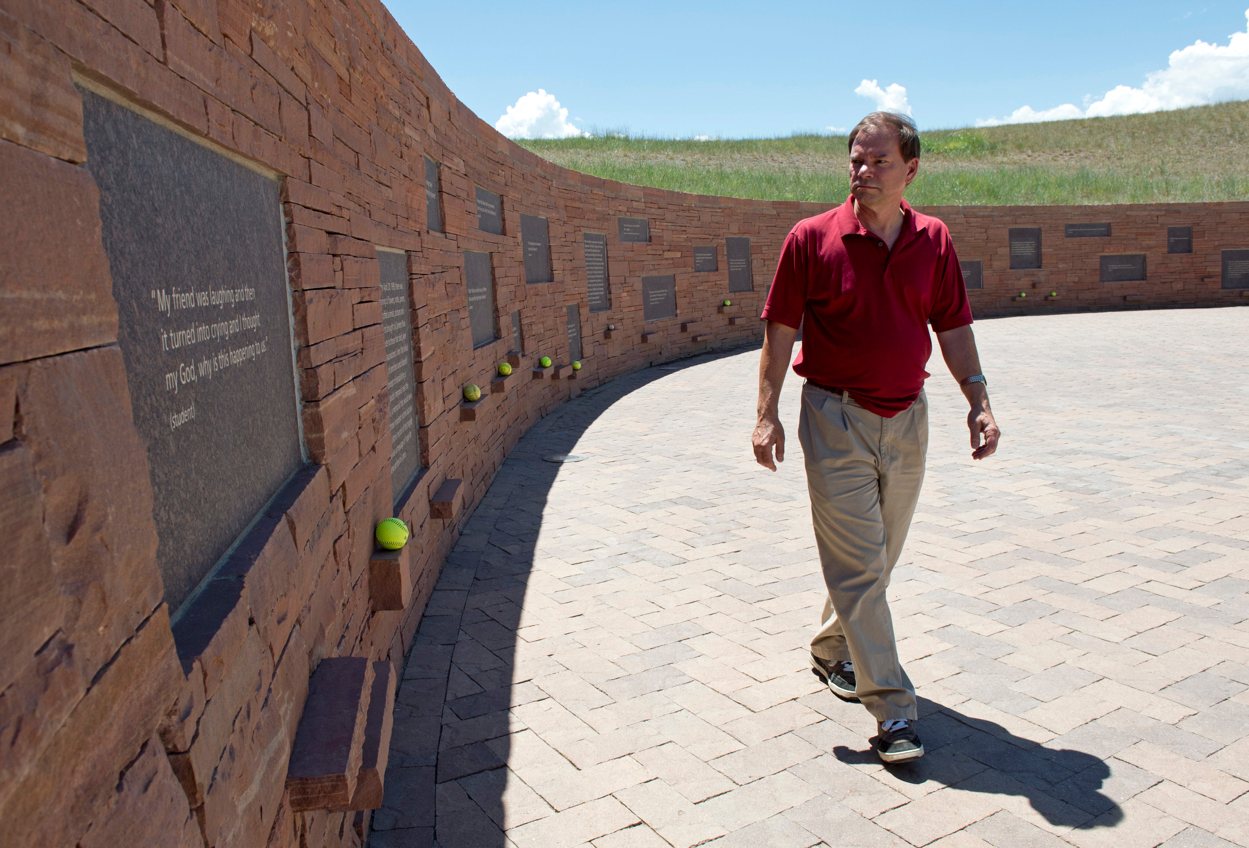 Tom Mauser, wearing his son Daniel's shoes, walks along a wall of the Columbine High School Memorial July 22, 2012 in Littleton, Colorado. Mauser, the father of Columbine High school shooting victim Daniel Mauser, has become an activist for increased gun control.