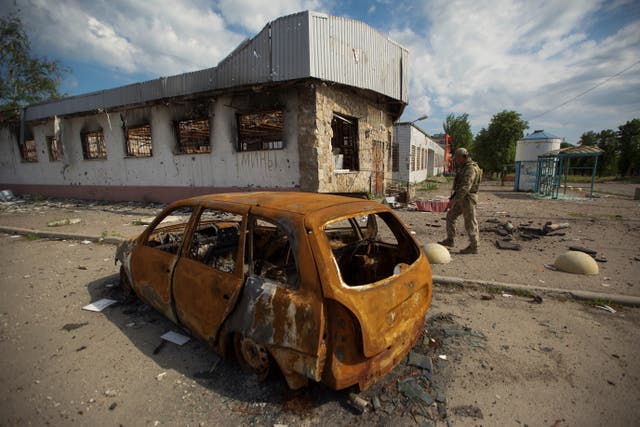 <p>A Ukrainian serviceman inspects an area damaged by a Russian military strike, as Russia's attack on Ukraine continues</p>