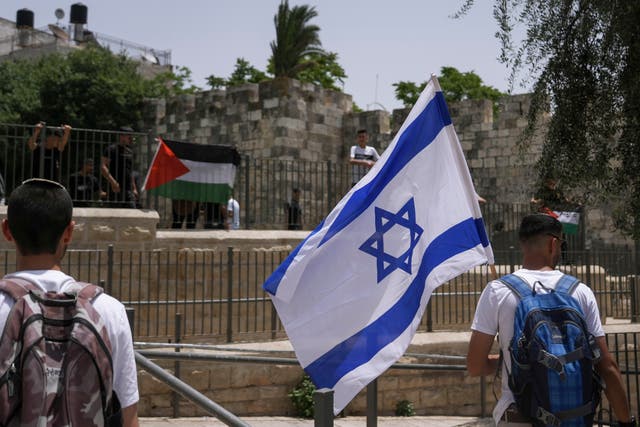 <p>File: Palestinians and Israelis wave their national flags outside Jerusalem's Old City as Israelis mark Jerusalem Day</p>