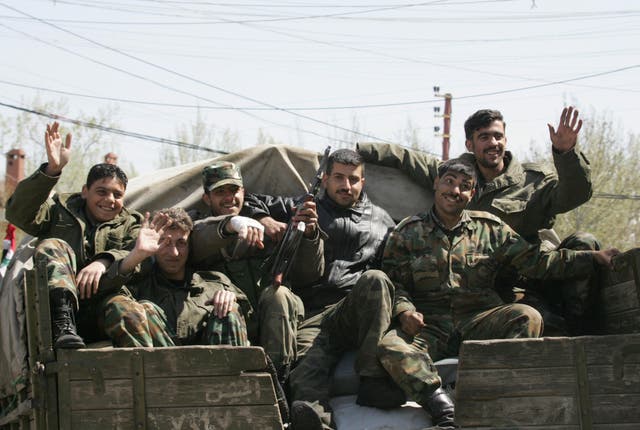 <p>Syrian soldiers sitting in Chtoura, in the Bekaa Valley, head to the Lebanese-Syrian border on 6 April 2005</p>