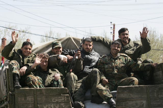 <p>Syrian soldiers sitting in Chtoura, in the Bekaa Valley, head to the Lebanese-Syrian border on 6 April 2005</p>