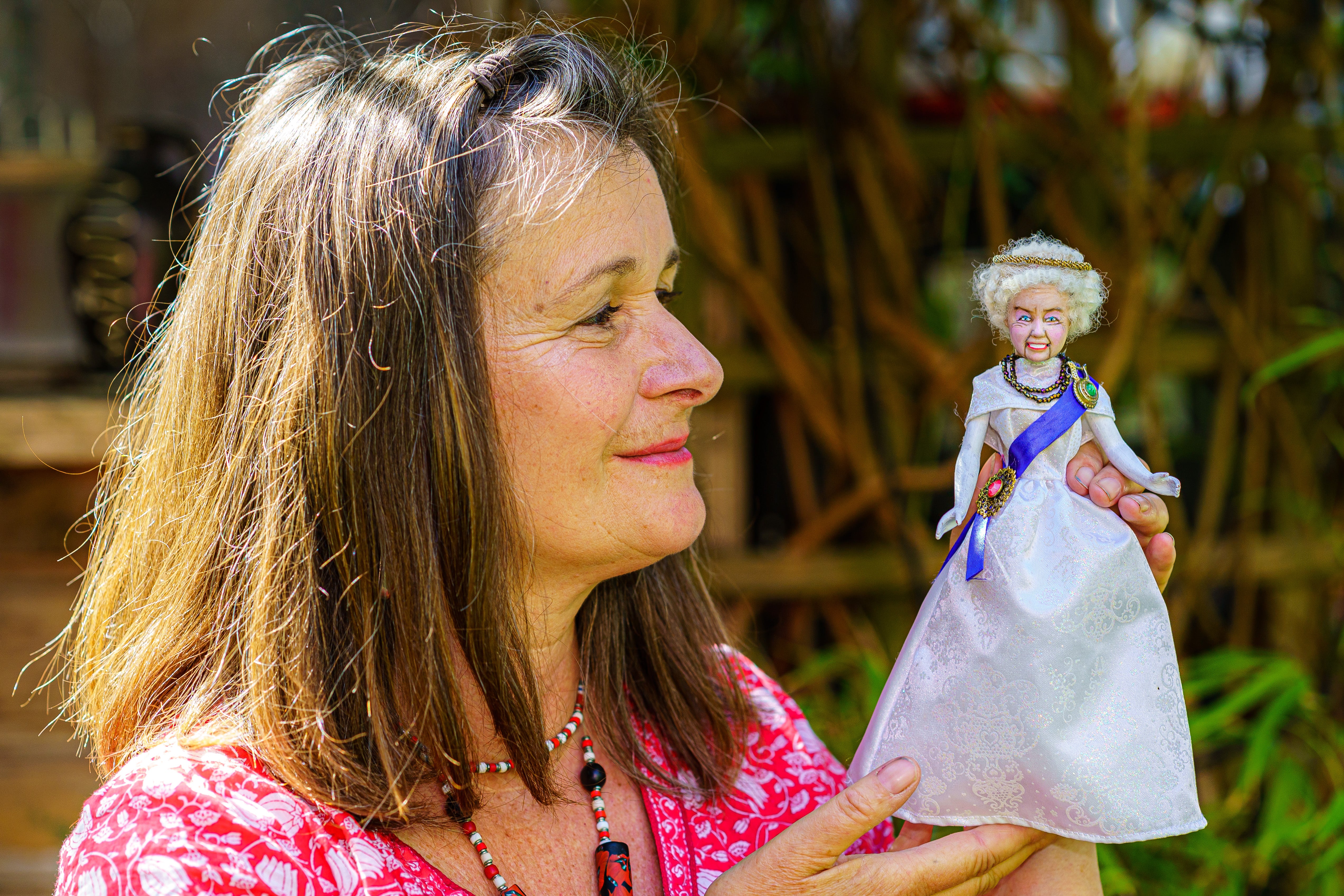 Artist Lou Gray, 61, holds a figure she made of Queen Elizabeth II at her home studio in Bristol, where she creates characters made from old dolls including Barbie, Ken and Action Man, plus other assorted miniature doll figures (Ben Birchall/PA Wire/PA Real Life)
