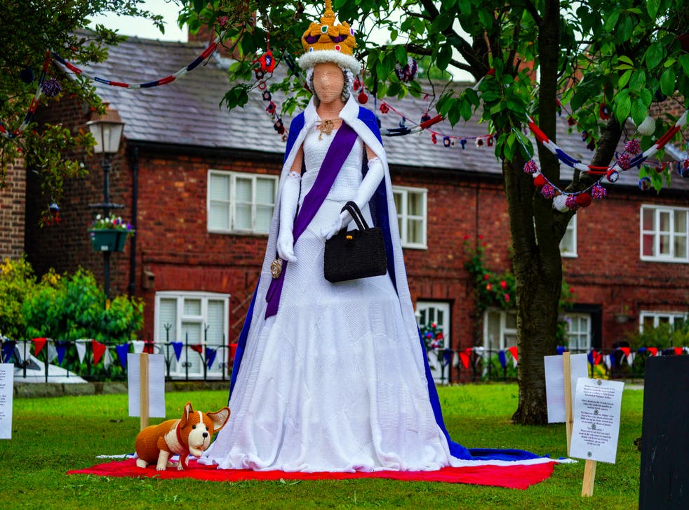 A life-size woollen Queen complete with a corgi created by a group of knitters for the Platinum Jubilee is proving a hit with locals in Holmes Chapel, Cheshire (Peter Byrne/PA)