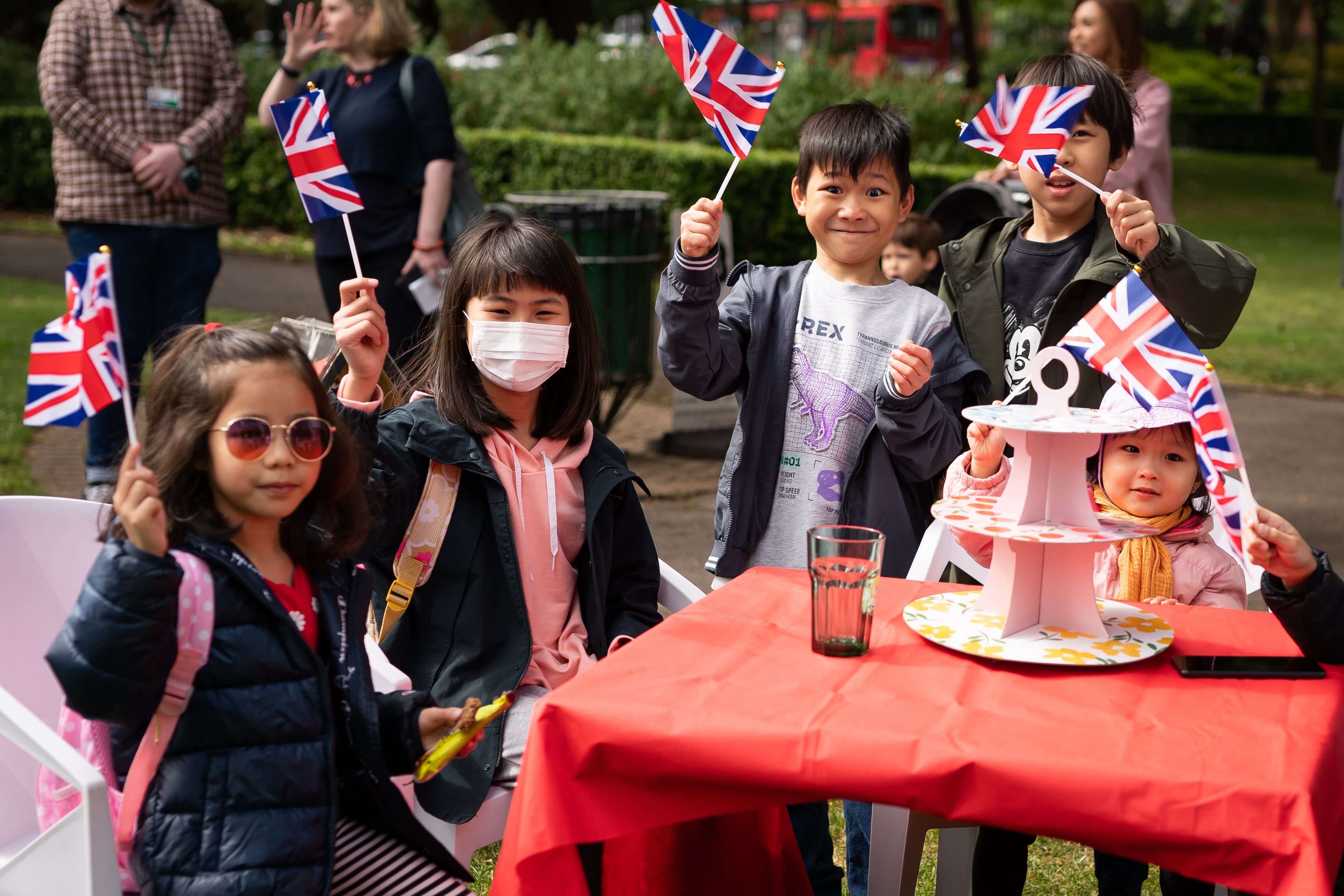 Newly arrived children from Hong Kong wave union flags during afternoon tea to mark the Queen’s Jubilee ahead of the Platinum Jubilee celebrations at the Manor Park Cafe, in Manor Park, Sutton (Aaron Chown/PA)