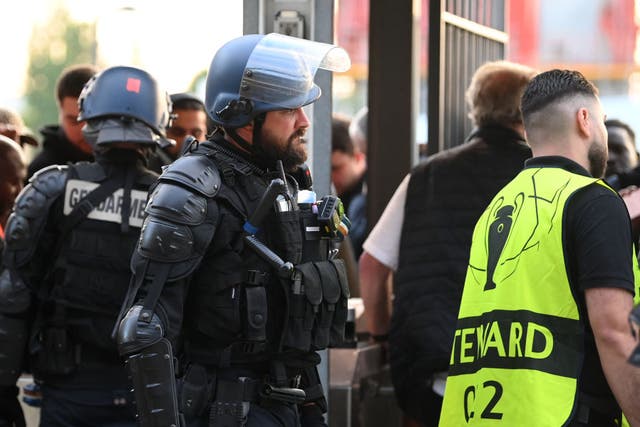 <p>Police and stewards are seen outside the Stade de France</p>