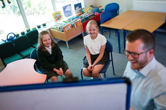 Ukrainian pupil Sofi (centre) and her classroom buddy Sylvia being taught by Tom Ormston at Glapthorn Primary School, in Oundle, Northamptonshire. Picture date: Tuesday May 24, 2022. PA Photo. Photo credit should read: Jacob King/PA Wire