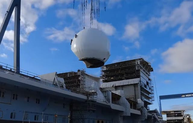 <p>The white sphere is lowered onto the 200,000-tonne ship</p>