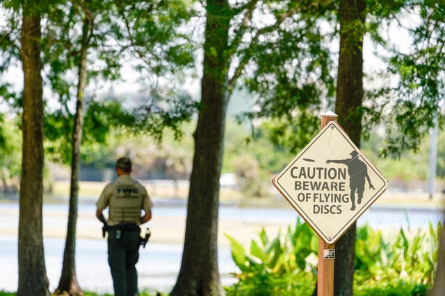 <p>A Florida Fish and Wildlife Conservation Commission officers stands by a lake in John S. Taylor Park, where a man was found dead Tuesday, May 31, 2022, in Largo, Fla</p>