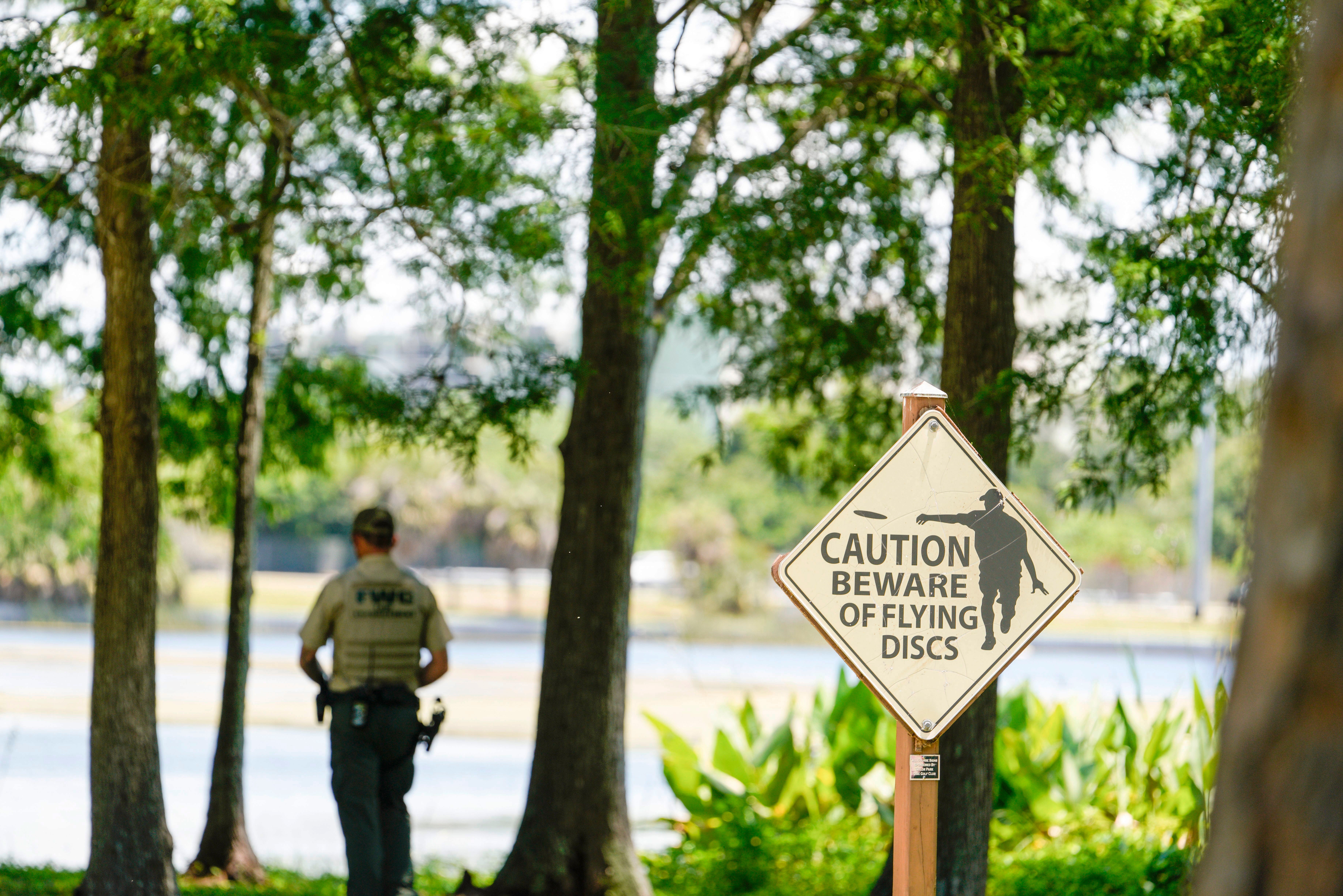 A Florida Fish and Wildlife Conservation Commission officers stands by a lake in John S. Taylor Park, where a man was found dead Tuesday, May 31, 2022, in Largo, Fla