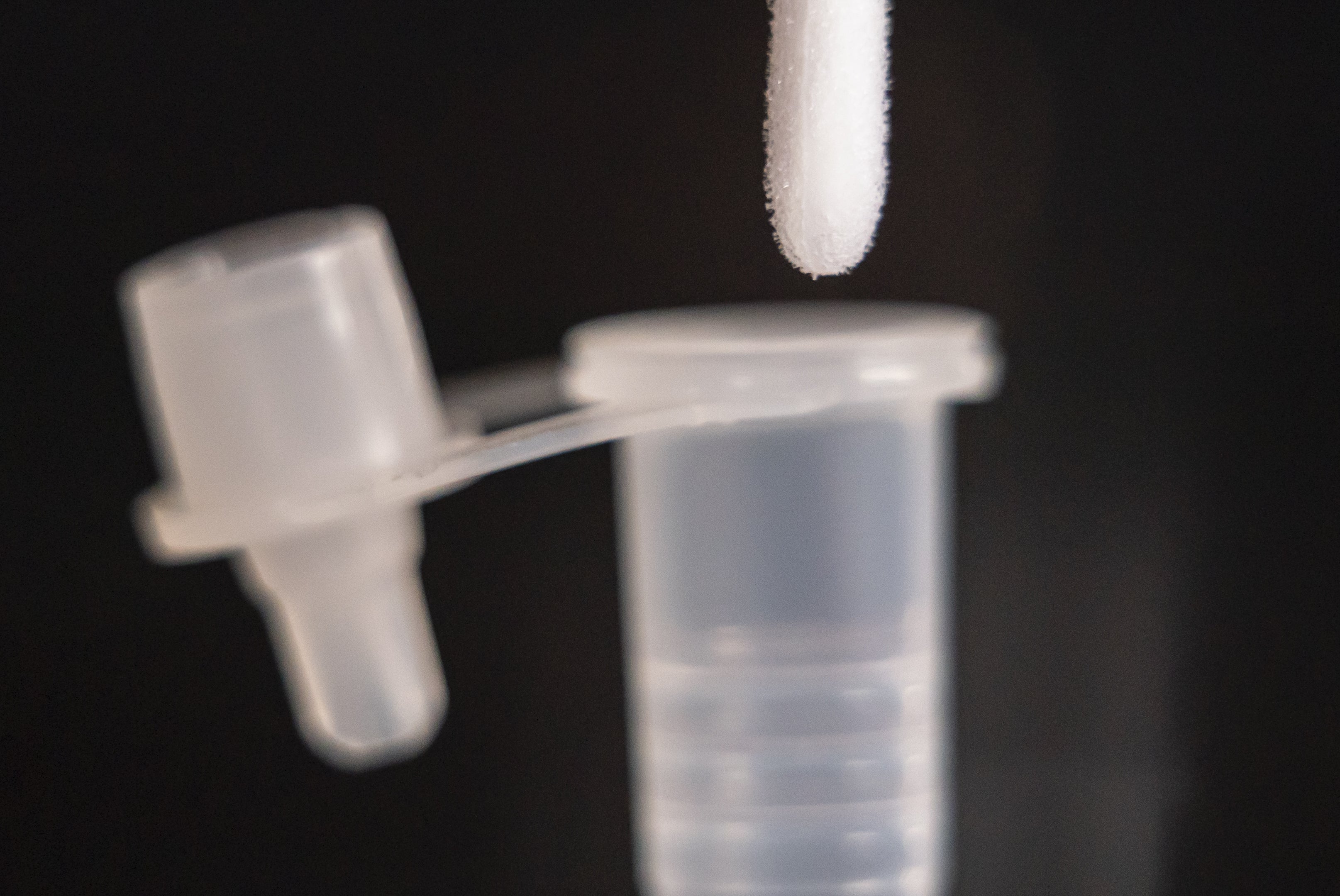 A person places a swab from a Covid-19 lateral flow test into a tube containing testing solution (Danny Lawson/PA)