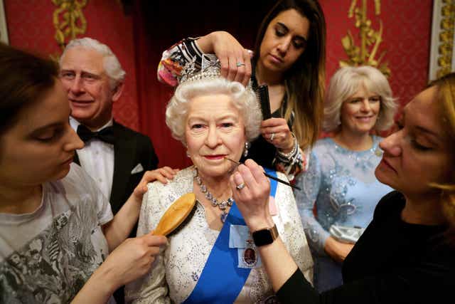 Studio artists Luisa Compobassi (left), Caryn Mitanni (back) and Jo Kinsey (right) make their final touches to the wax figure of Queen Elizabeth II at Madame Tussauds London ahead the Platinum Jubilee celebrations. Picture date: Wednesday May 25, 2022. (Victoria Jones/PA)