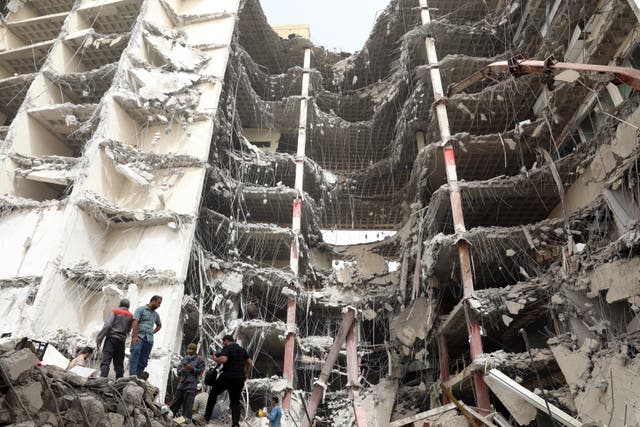 <p>Members of Red Crescent and officials work at the site where a ten-storey building collapsed the in city of Abadan</p>