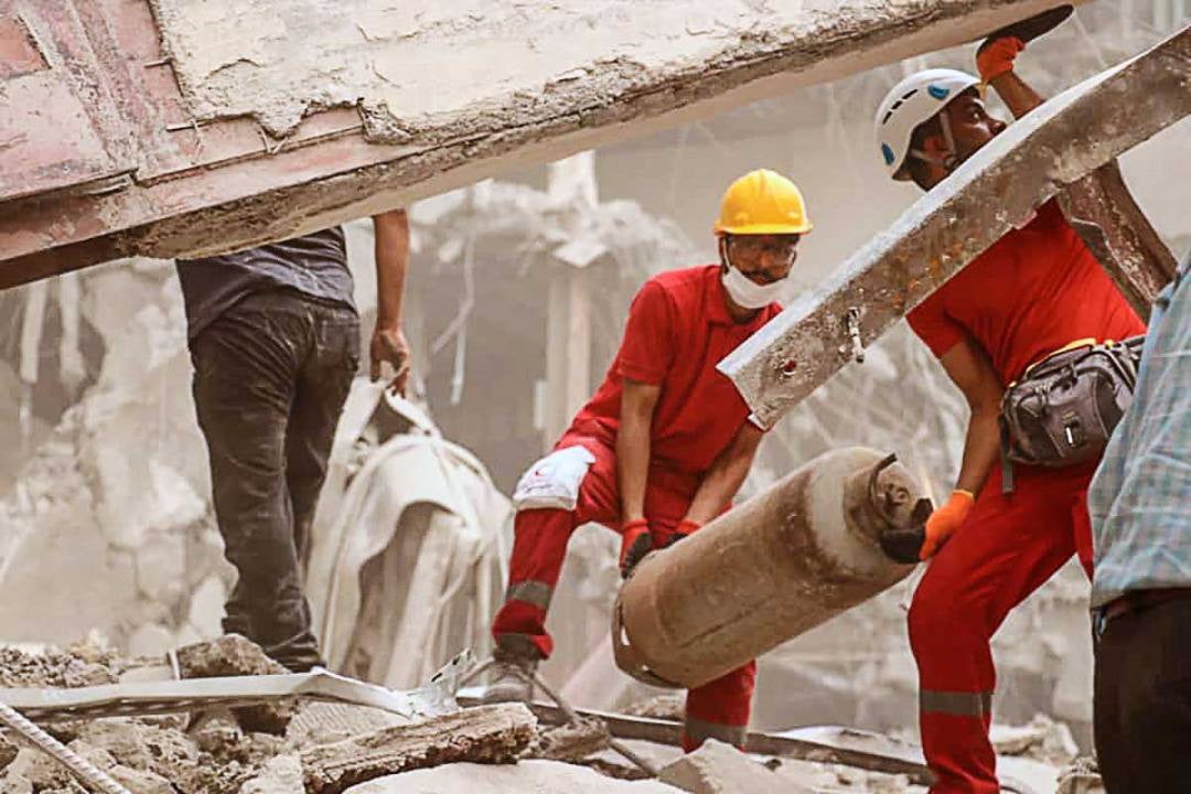 Iranian Red Crescent Society workers help clear the collapsed building