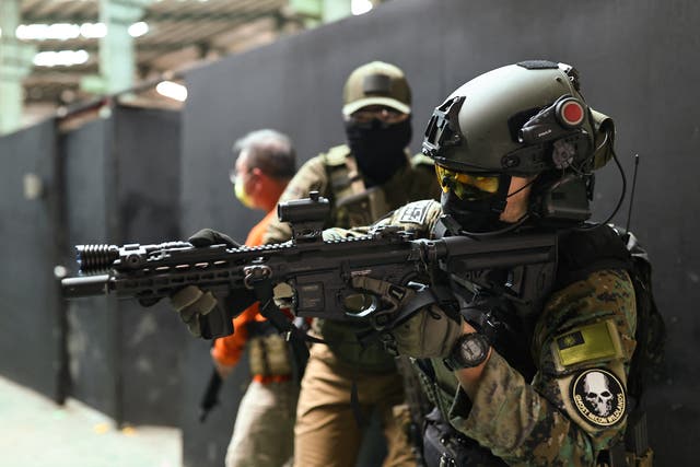<p>Trainees prepare to enter a building with their airsoft guns during a shooting lesson</p>