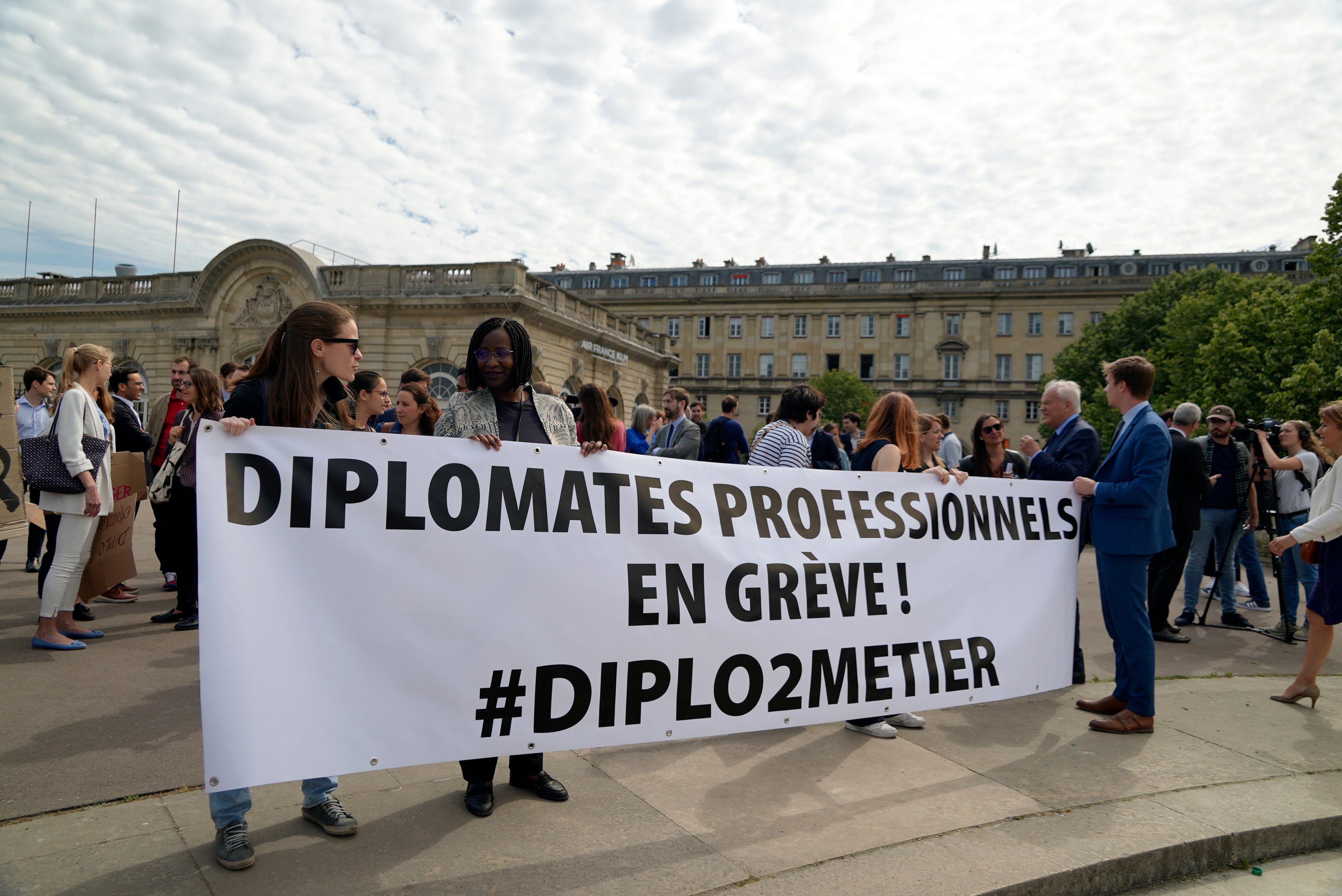 Diplomats hold a banner reading “Professional diplomats on strike” during a protest near the French Foreign Ministry in Paris