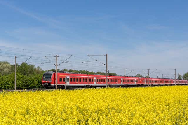 <p>A German Deutsche Bahn service travels through Bavarian countryside</p>