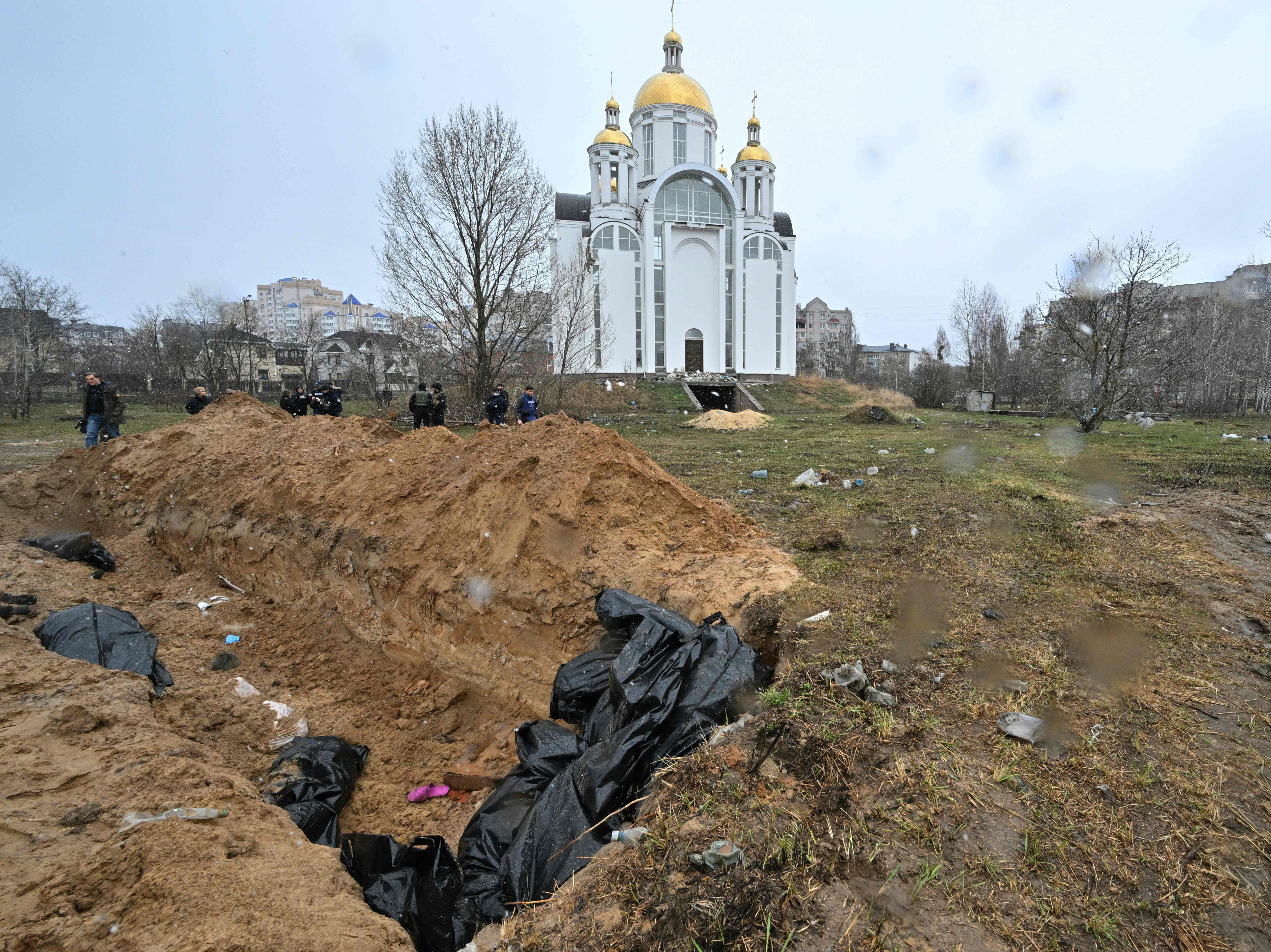 A mass grave is seen behind a church in the town of Bucha on 3 April