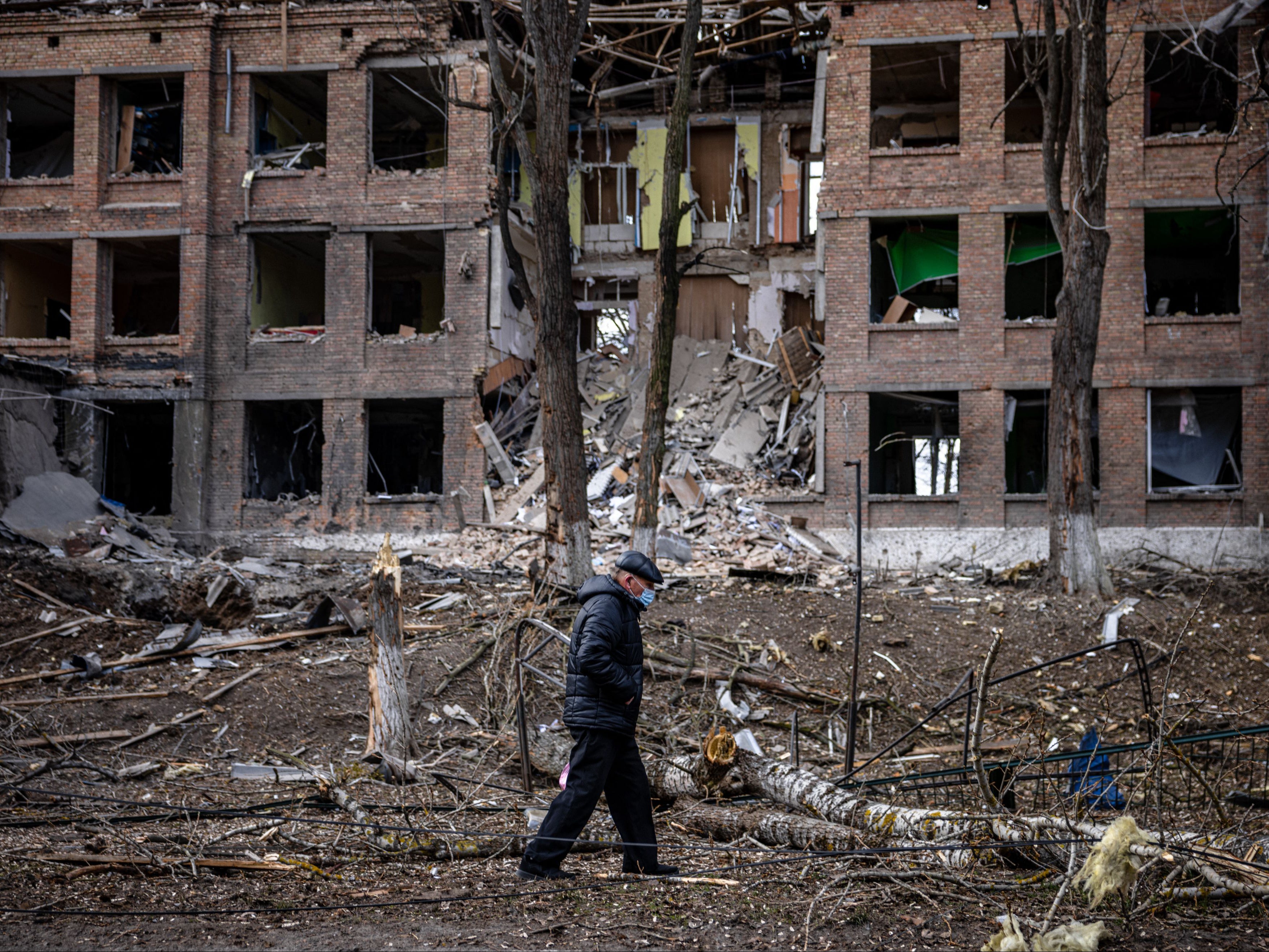 A man walks in front of a destroyed building after a Russian missile attack in the town of Vasylkiv, near Kyiv, on 27 February