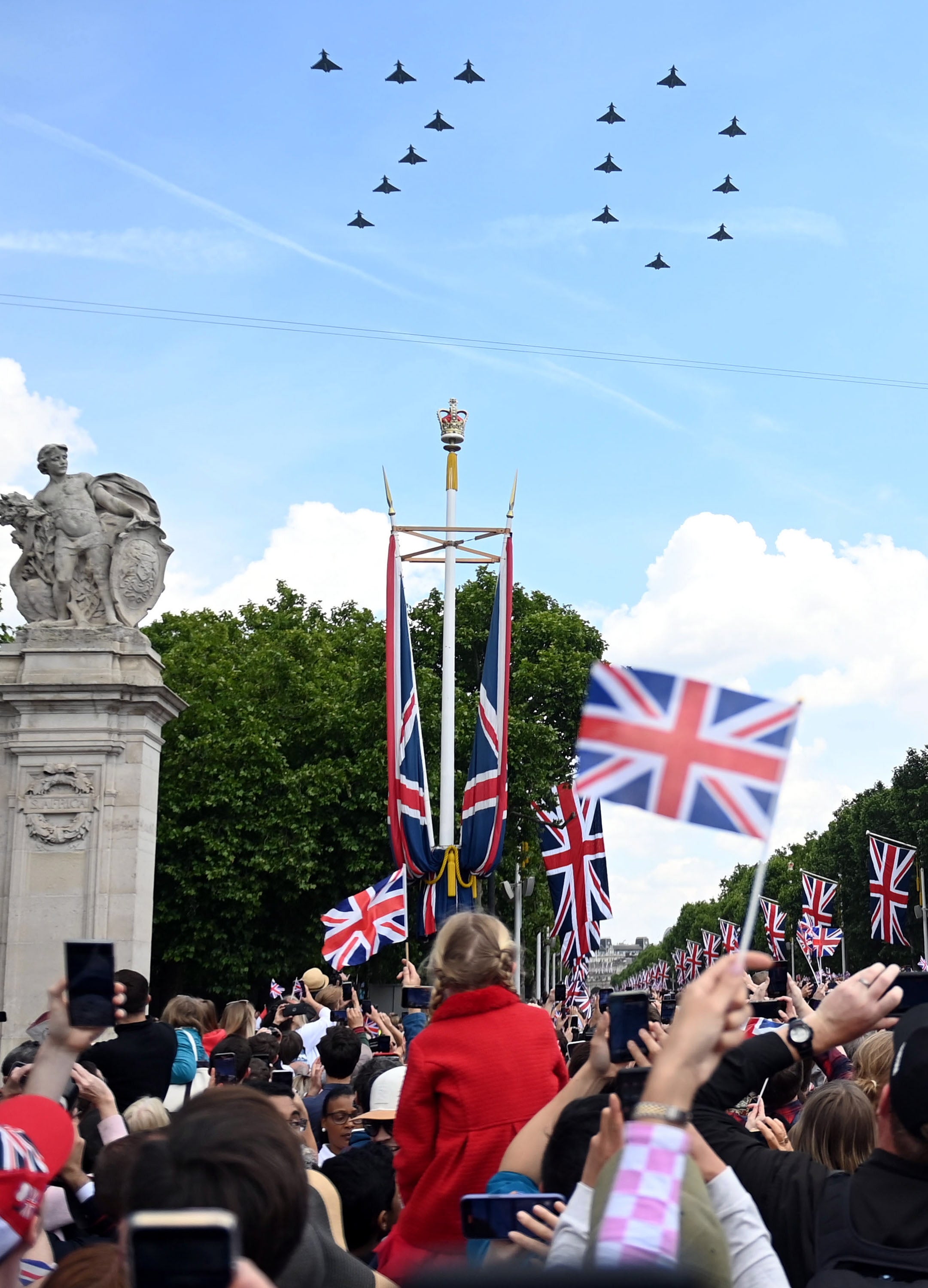 Crowds watch a fly past spelling out the number 70
