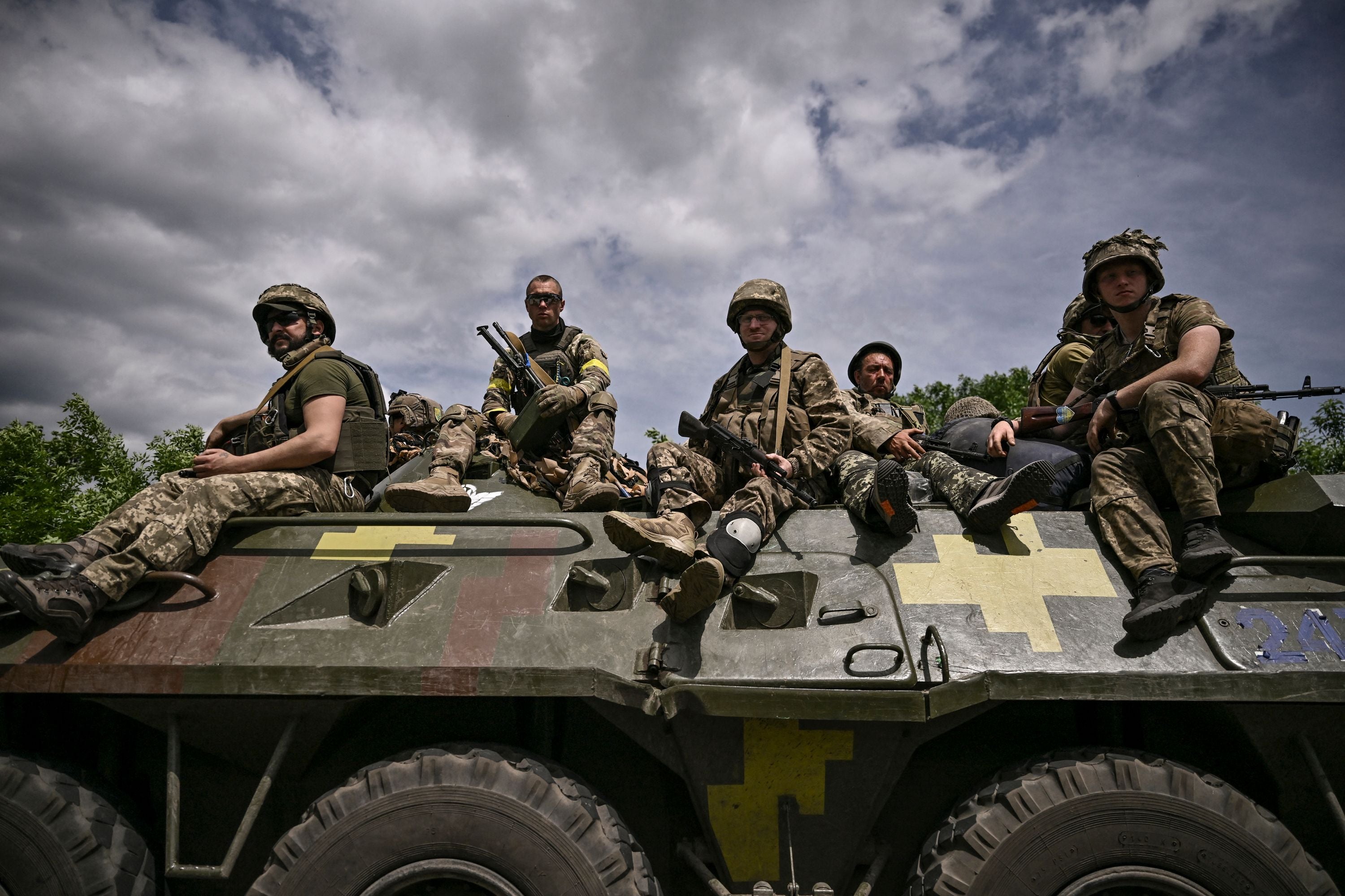 Ukrainian troops sit on an armoured vehicle as they move back from the front line near the city of Slovyansk in the Donbas