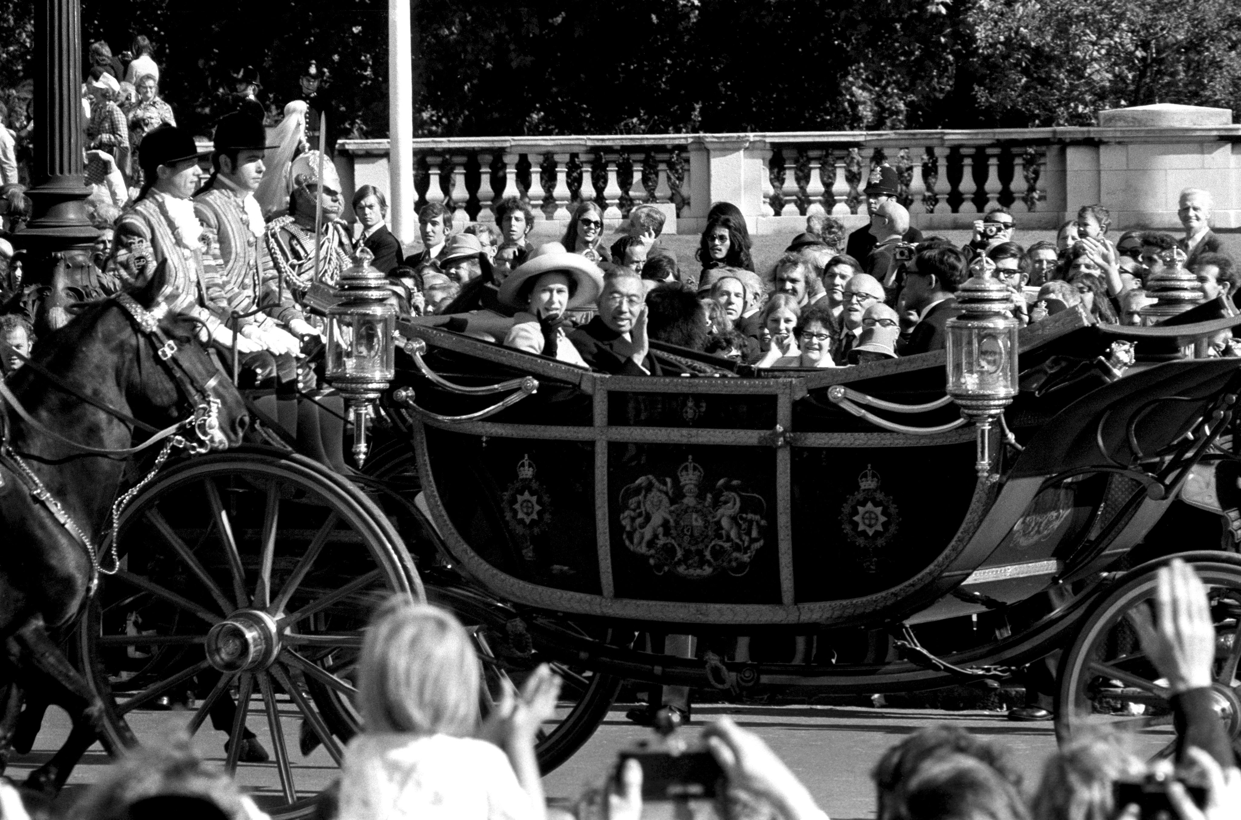 Queen Elizabeth II accompanies Emperor Hirohito in an open carriage to Buckingham Palace at the start of his state visit to Britain in 1971