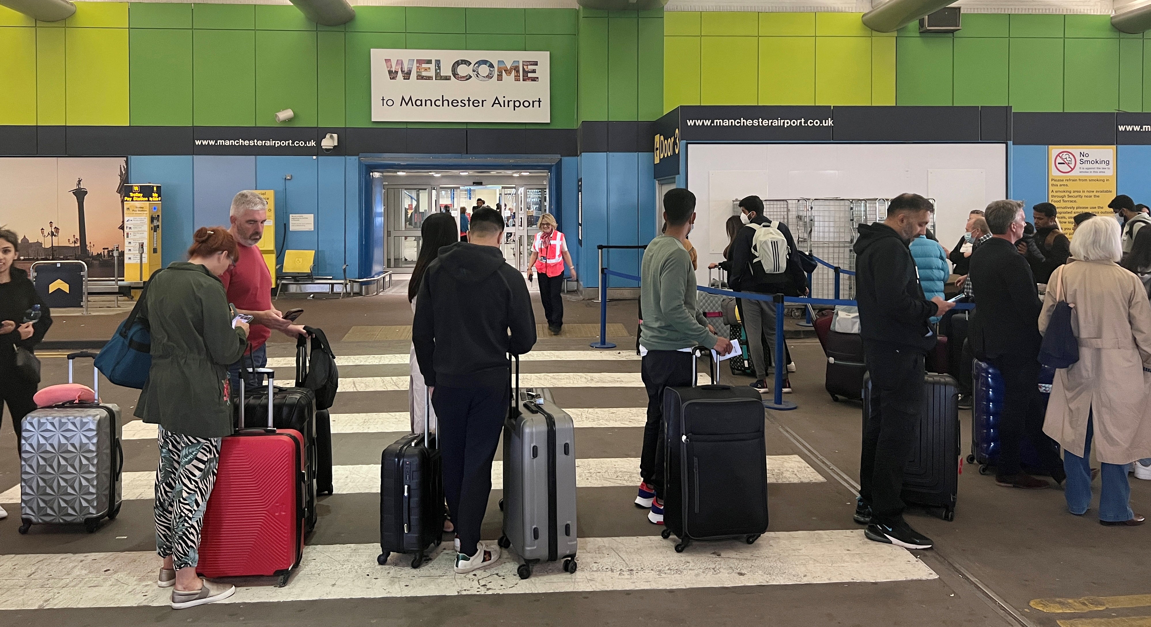 Passengers queue for check-in outside Terminal 1 at Manchester airport on Wednesday