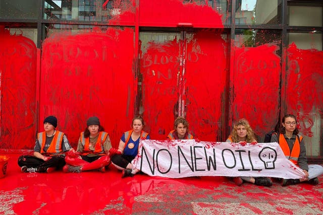 <p>The protesters, who are calling on the government to halt all new oil and gas licences, scrawled ‘blood on your hands’ in red paint</p>