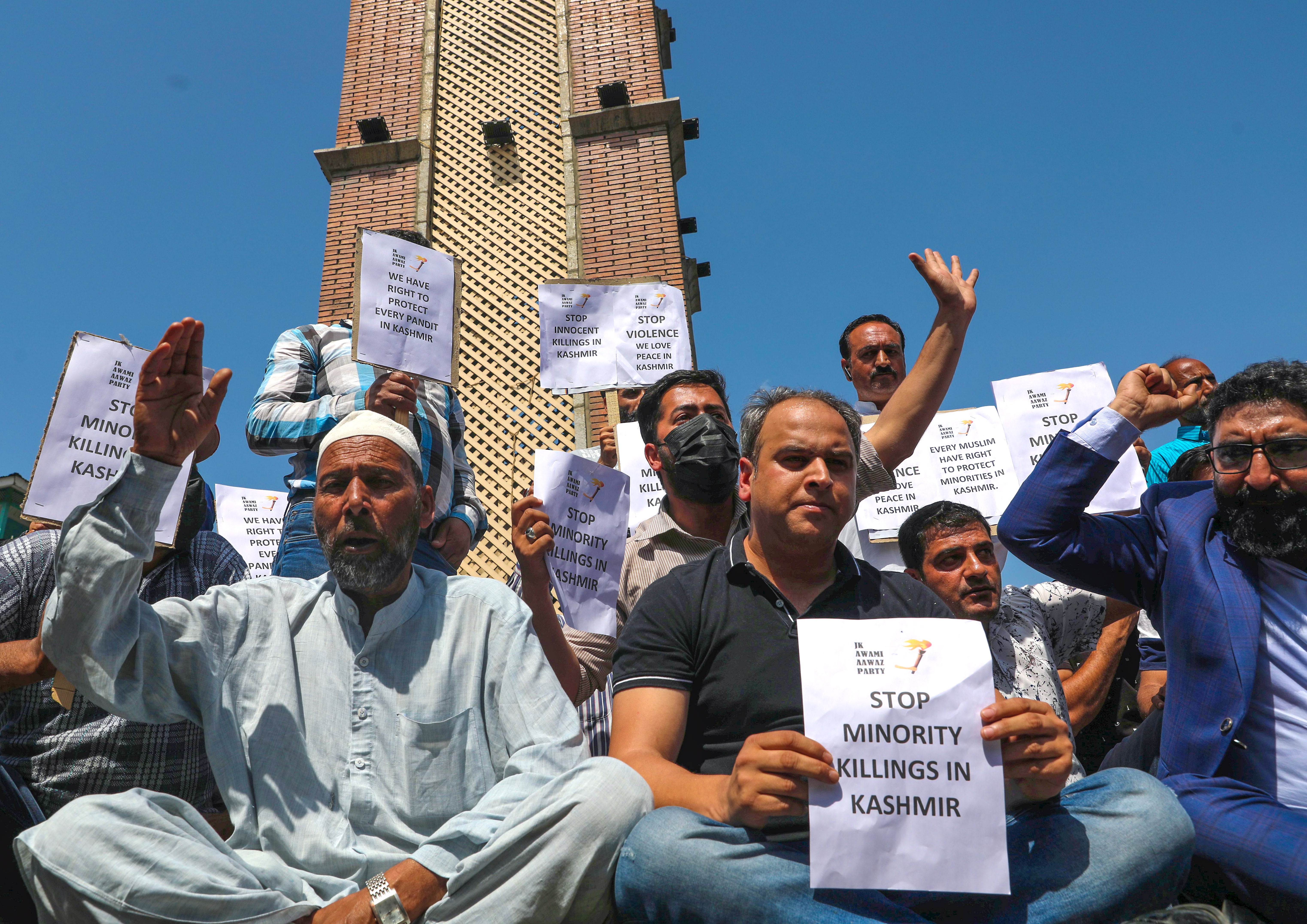 Members of Kashmiri political party JK Awami Aawaz Party hold placards as they take part in a protest against minority killings in Srinagar on 2 June