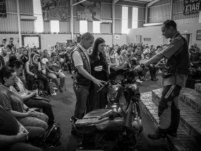 <p>Pastor Mozzy Delpeche (right) leads a prayer for a couple who had recently purchased a new motorcycle at a weekly CMA service in Johannesburg</p>