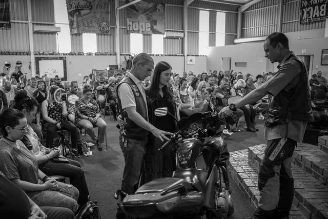 <p>Pastor Mozzy Delpeche (right) leads a prayer for a couple who had recently purchased a new motorcycle at a weekly CMA service in Johannesburg</p>