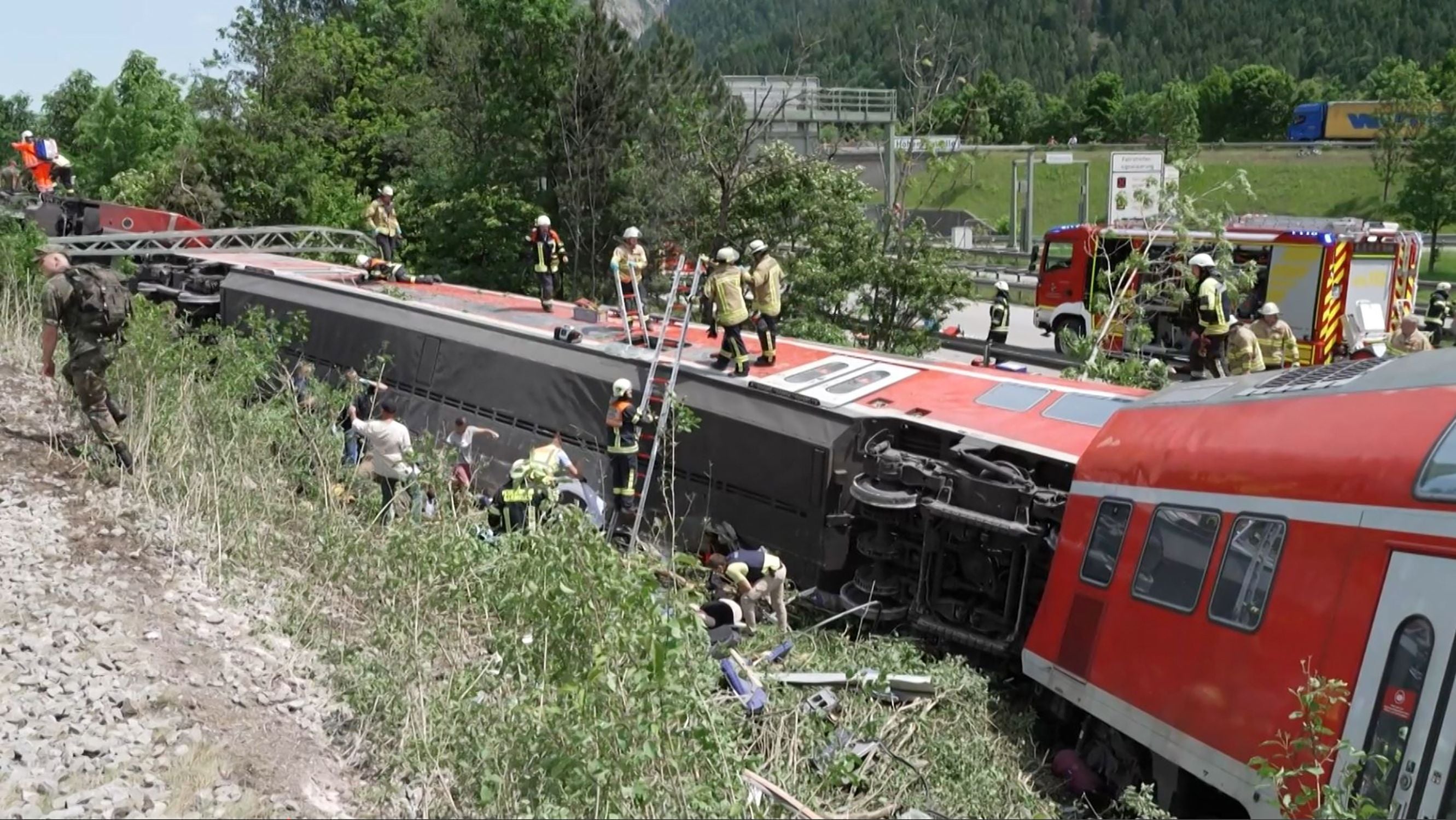 Rescuers standing on an overturned carriage in Burgrain, near Garmisch-Partekirchen, southern Germany