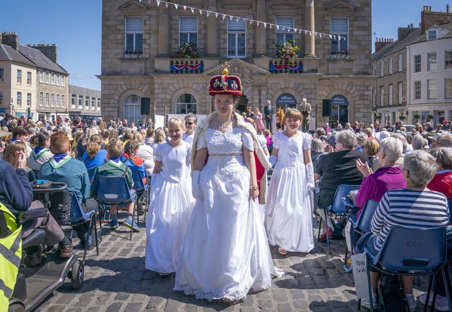 Susannah Ayling, 12, plays the part of The Queen in a re-enactment of the Queen’s coronation performed by a cast from members of the local Cubs, Scouts and Guides in the town square during Platinum Jubilee celebrations in Kelso, on day three of the Platinum Jubilee celebrations for Queen Elizabeth II (Jane Barlow/PA)