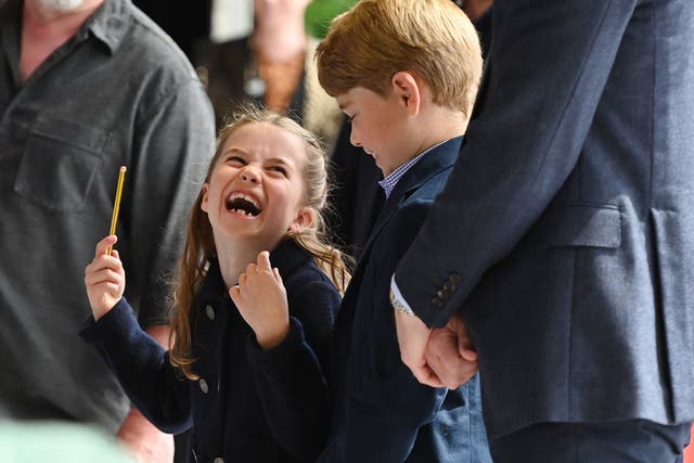 <p>Princess Charlotte laughs as she conducts a band next to her brother, Prince George,  during their visit to Cardiff Castle</p>