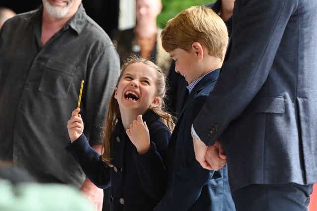 Princess Charlotte laughs as she conducts a band next to her brother, Prince George, during their visit to Cardiff Castle (Ashley Crowden/PA)