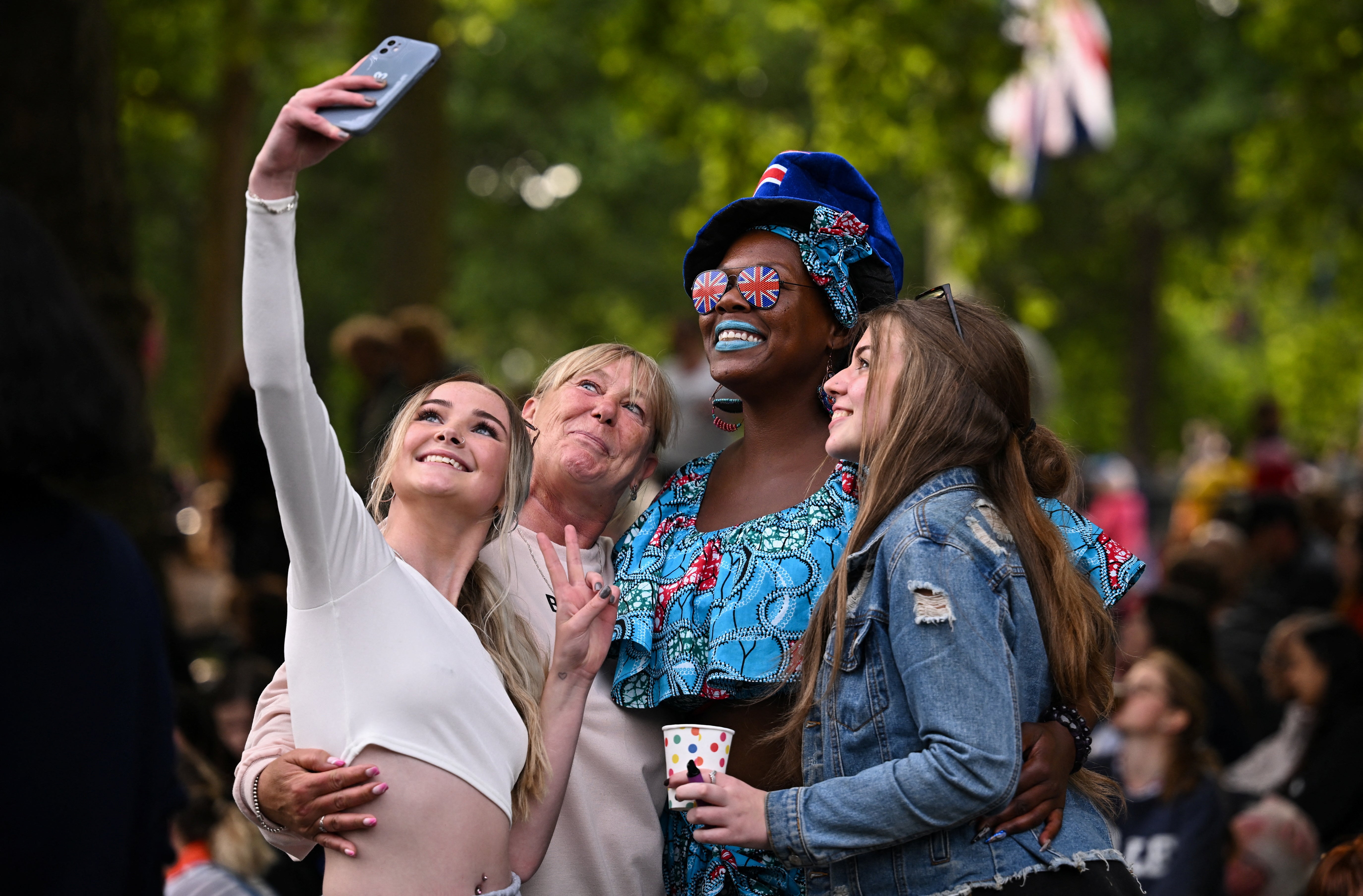 People take a selfie by The Mall ahead of a concert outside Buckingham Palac