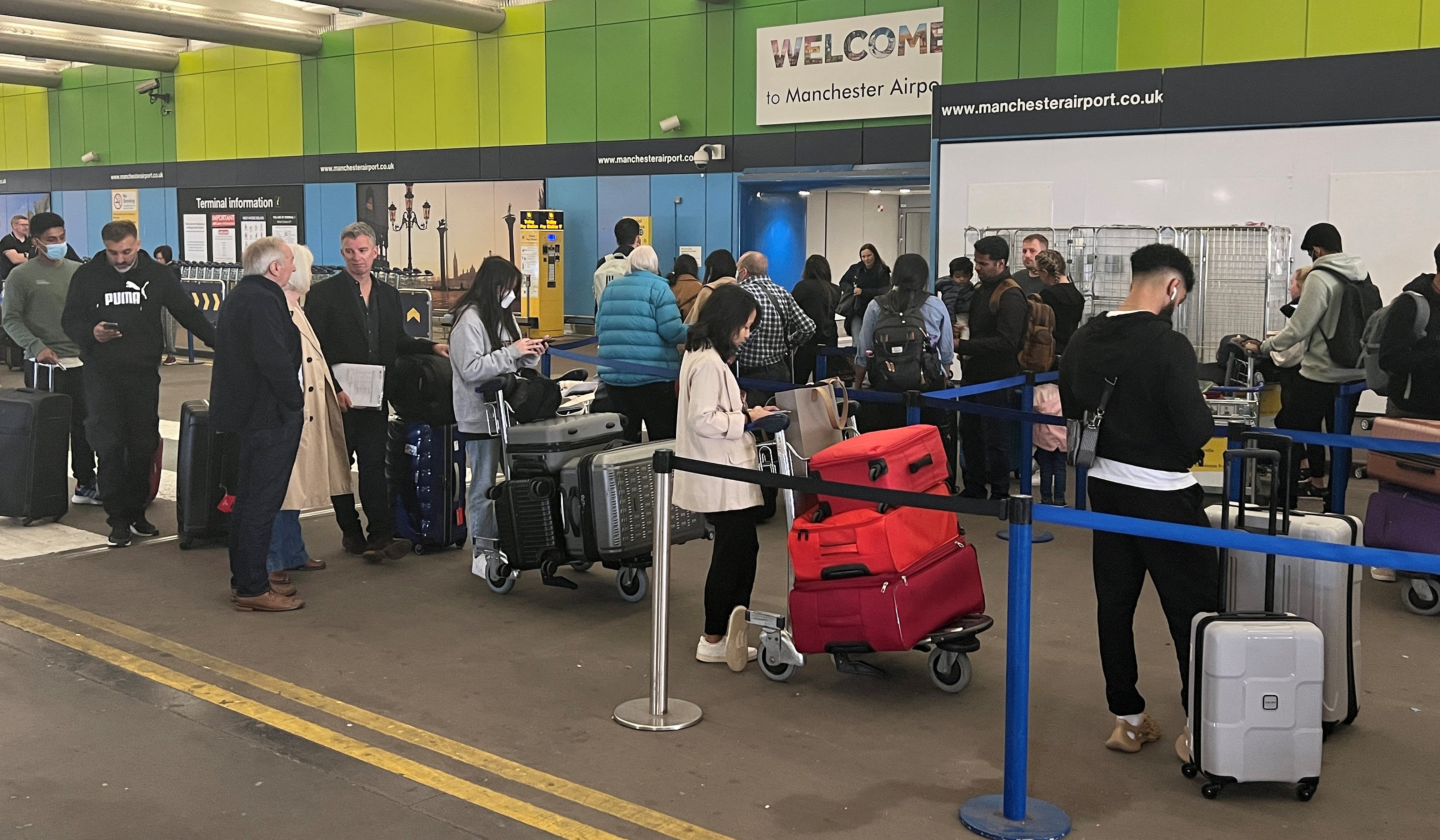 Passengers queue outside Manchester Airport in June 2022