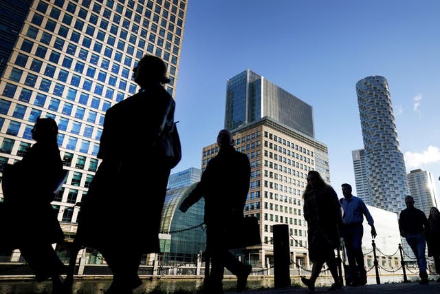 Office workers and commuters walk through Canary Wharf in London during the morning rush (Victoria Jones/PA)