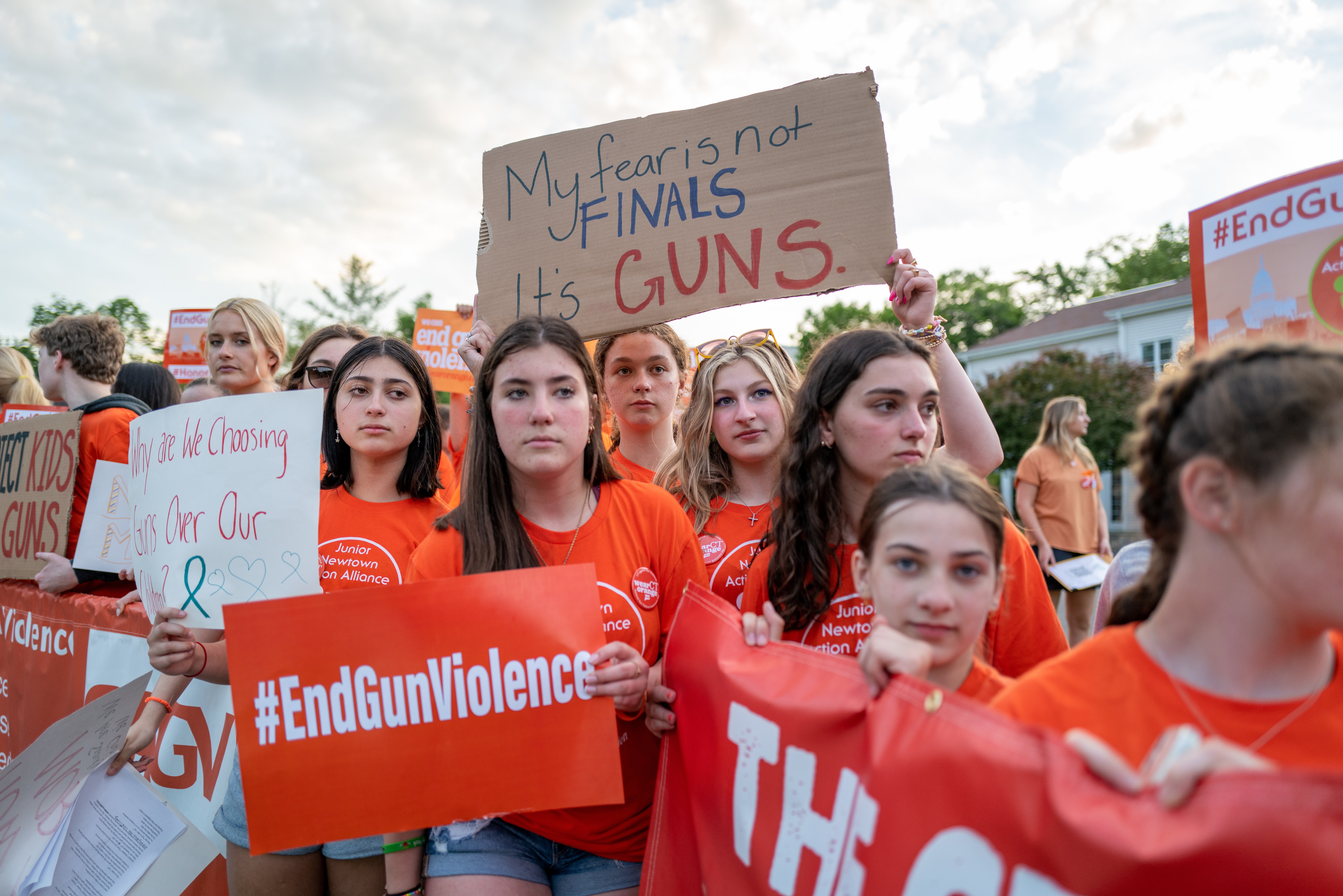 People hold up signs during a rally for National Gun Violence Awareness Day on 3 June