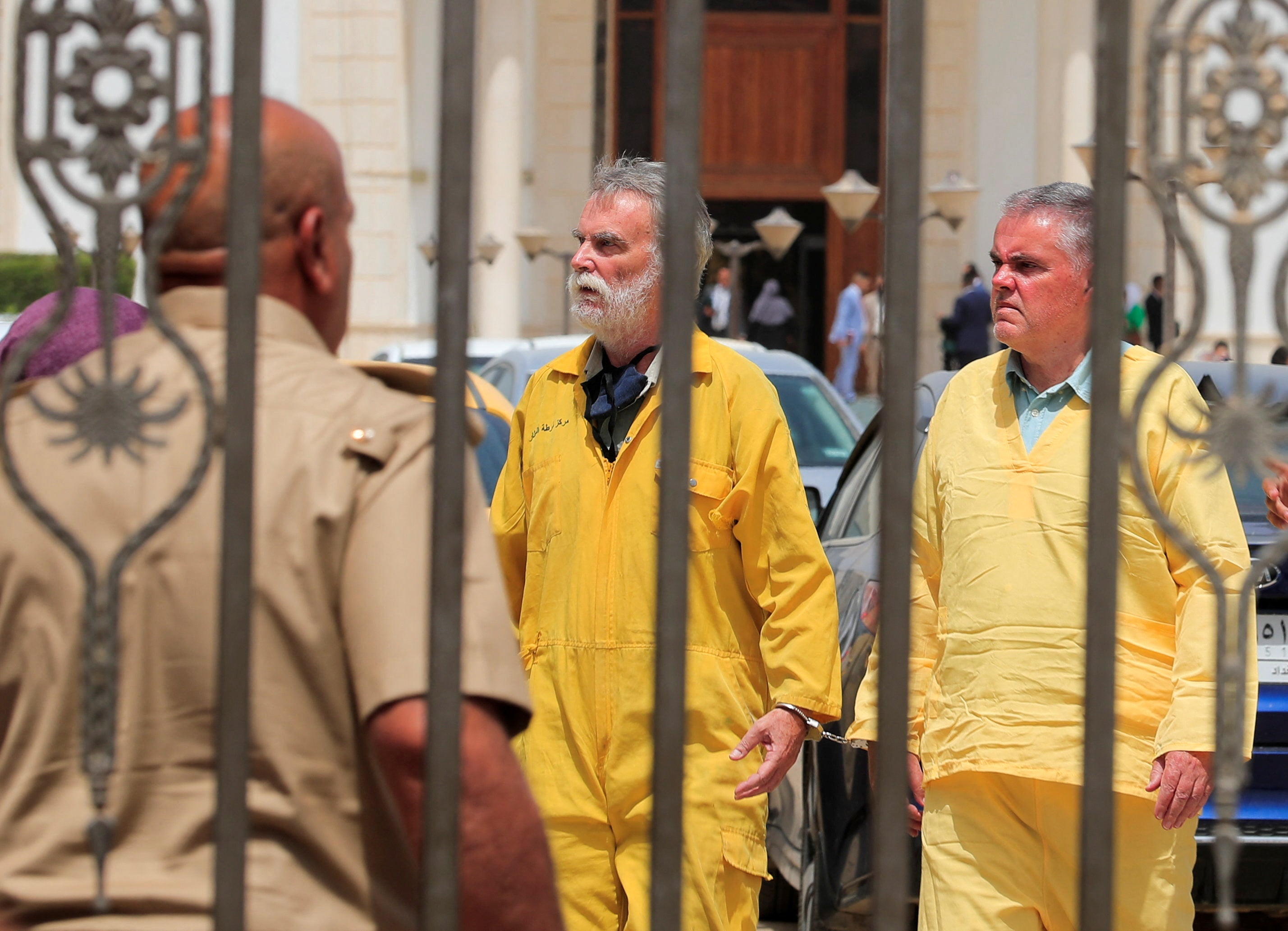 Jim Fitton (centre) and Volker Waldmann (right) stand outside the court in Baghdad on 22 May