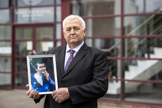 Glynn Brown outside the Corn Exchange, Cathedral Quarter in Belfast, holding an image of his son Aaron who was a patient at Muckamore Abbey Hospital, as the first day of public hearings in the Muckamore Abbey Hospital Inquiry is under way (Liam McBurney/PA)