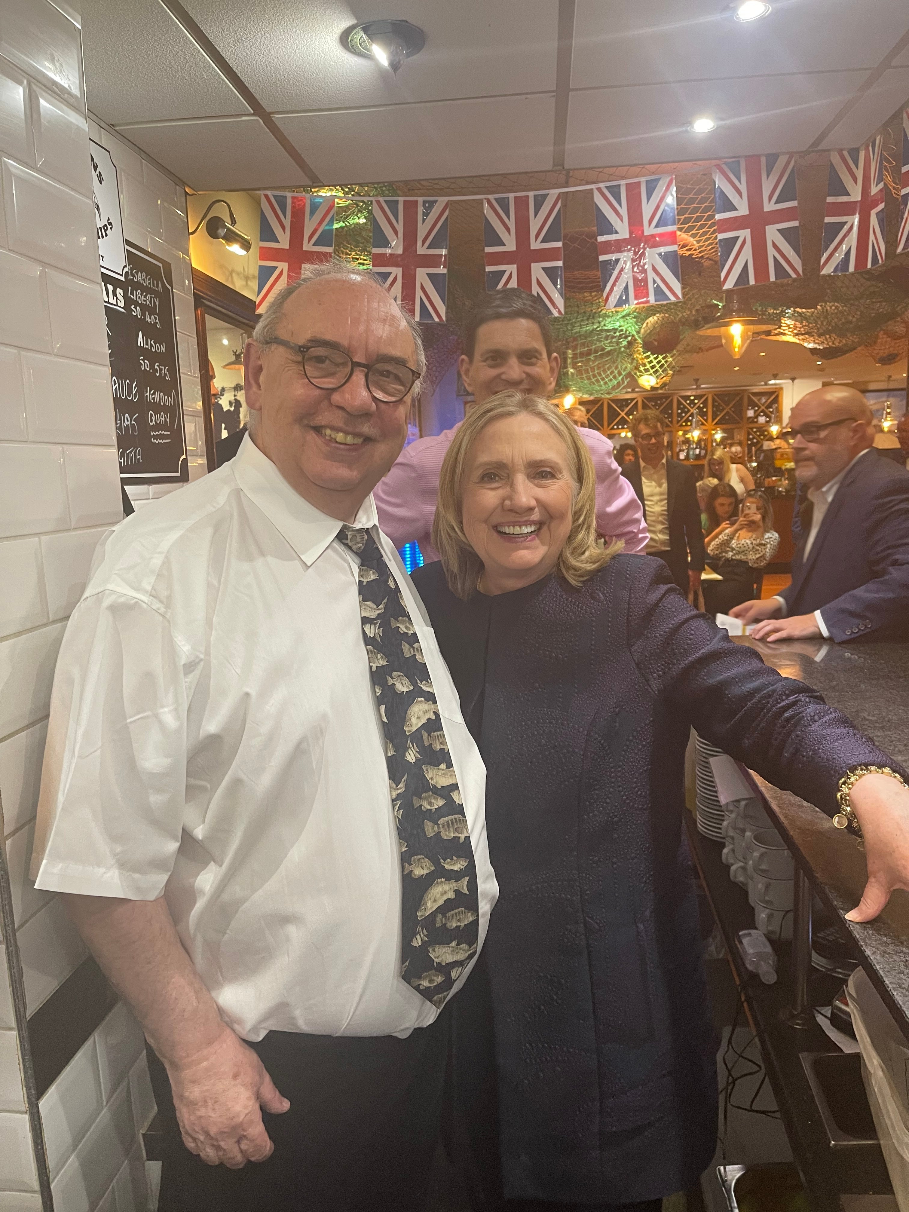 Hillary Clinton is greeted by Richard Ord senior, with former MP David Miliband behind, at Colman’s restaurant in South Shields (Richard Ord/PA)