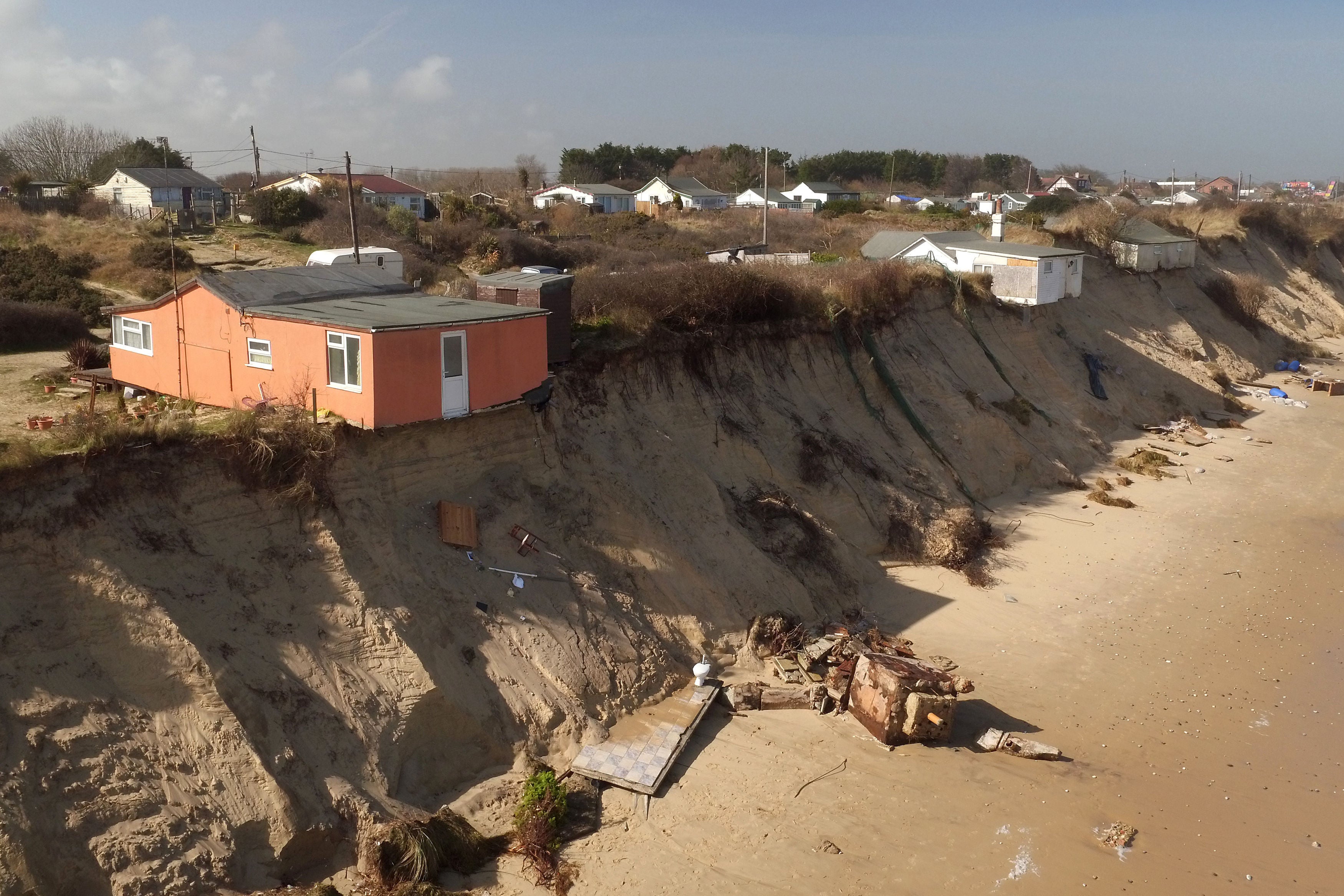 Houses sit on the cliff edge on The Marrams in Hemsby, Norfolk (PA)