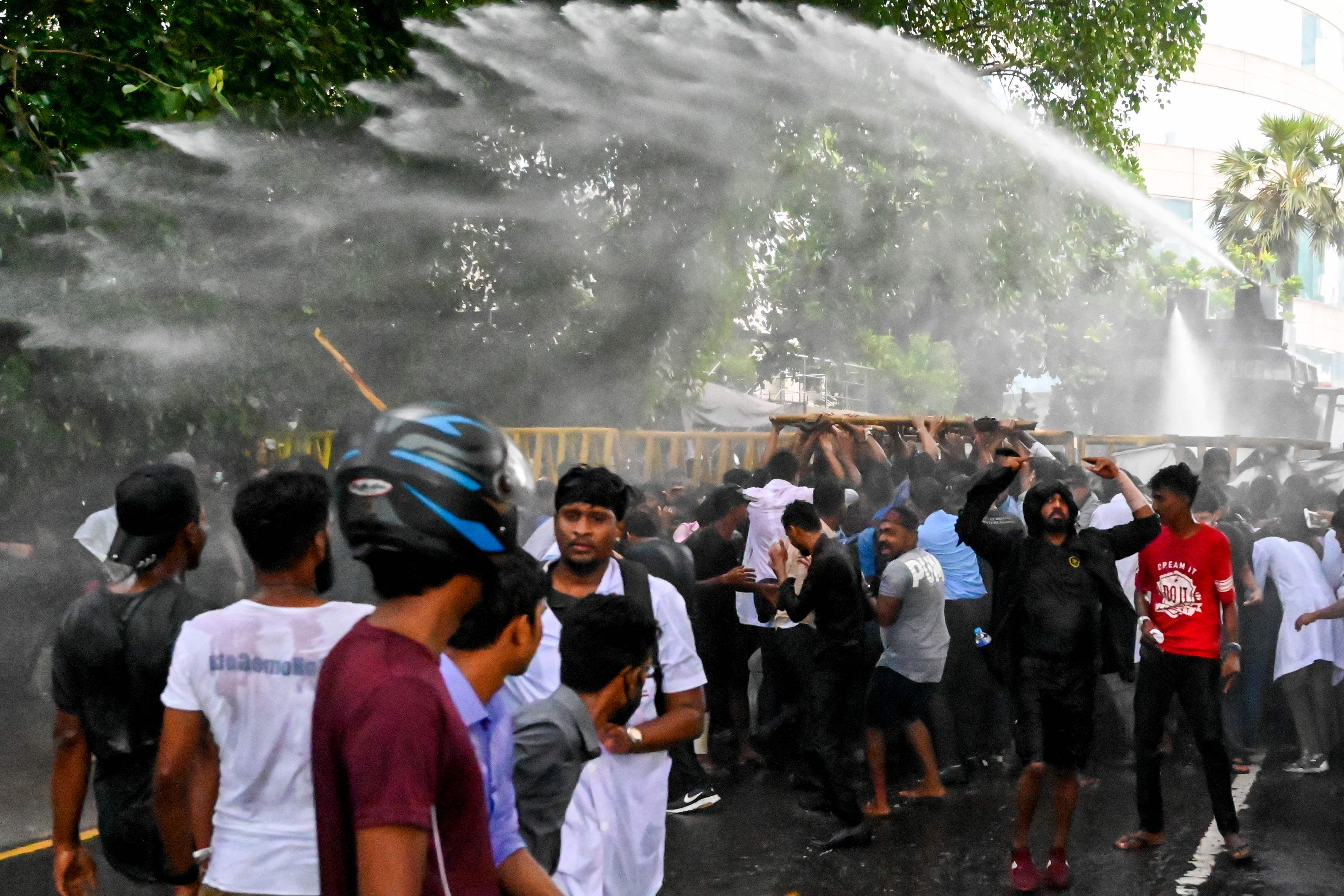 Police use a water canon to disperse students from during an anti-government demonstration on 29 May in Colombo