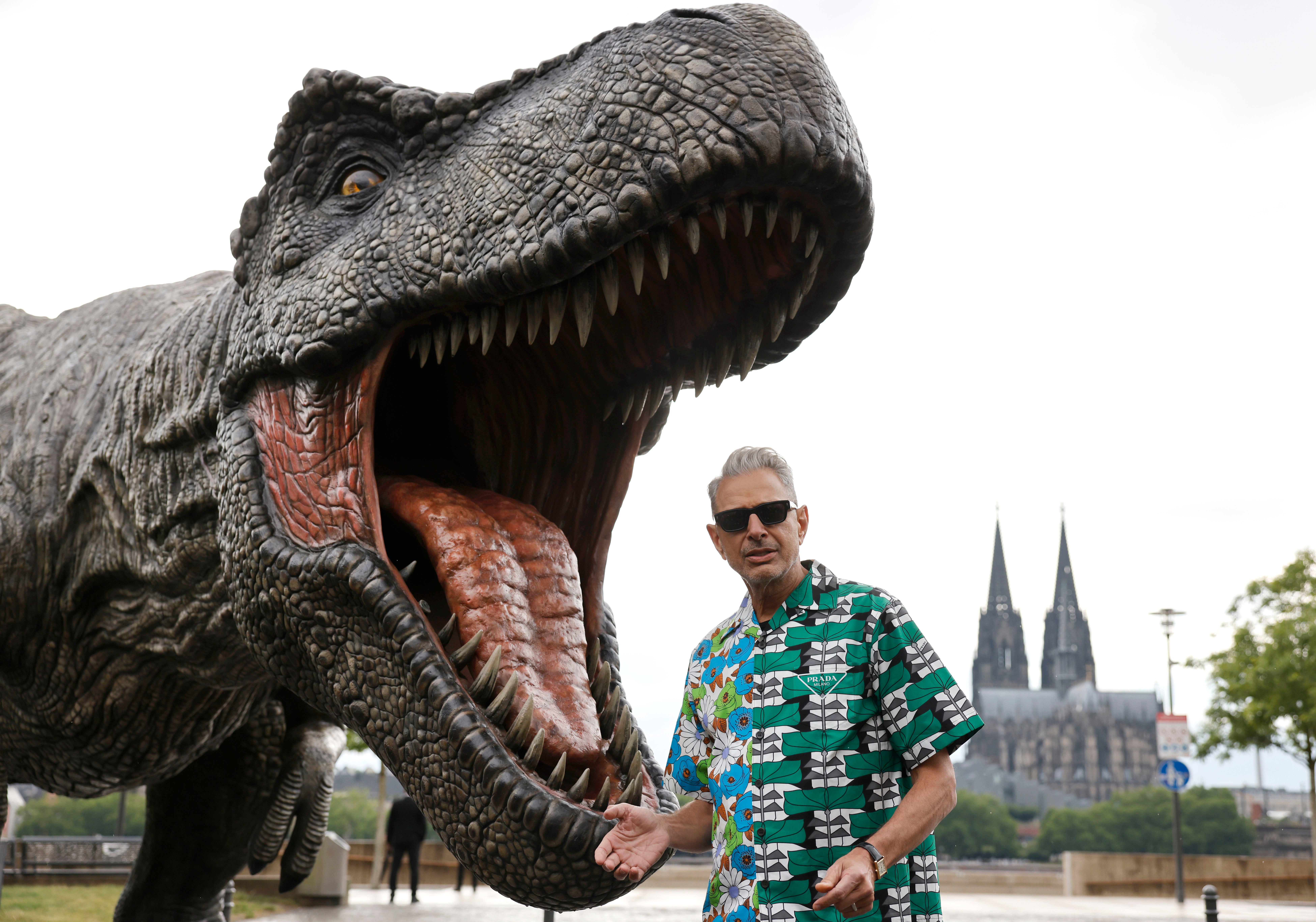 Actor Jeff Goldblum stands in front of a T-Rex figure, with the Cologne Cathedral in the background, during a photocall for the new film - Jurassic World Dominion